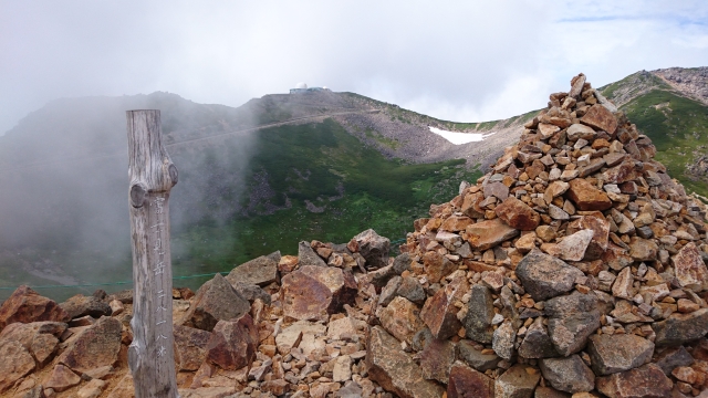 富士見岳山頂。標高2818m。正面の山頂に見える建物はコロナ観測所。